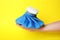 Woman holding ice pack against yellow background