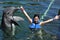 Woman holding a kiss from a dolphin.