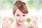 Woman holding kiwi fruit cover her eyes