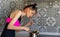 Woman holding a ladle of cooked pasta and tasting a spaghetti, cooking in the kitchen