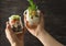 Woman holding mason jars with delicious vegetable and chicken salads on dark background