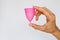 woman holding menstrual cup on white background. Feminine hygiene alternative product instead of tampon during period.