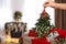Woman holding mistletoe bunch in room with Christmas decorations, closeup. Space for text