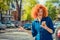 Woman holding mobile phone, hitch hiking in the city street