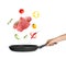 Woman holding nonstick frying pan with falling beef slices and vegetables on white background.