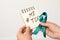 Woman holding notebook with hashtag MeToo and teal awareness ribbon against light background. Stop sexual assault