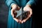 A woman holding an old and rusty star of David in their hands.