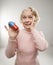 Woman holding oversized pill.