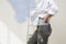 Woman Holding Paintbrush By Stepladder Against Unpainted Wall