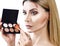 Woman holding palette for contouring face.