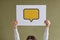 Woman holding paper card with yellow blank mockup speech balloon or message icon