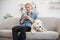 Woman holding phone while terrier having rest on couch