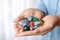 Woman holding pile of different gemstones indoors