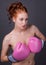 Woman Holding Pink Boxing Gloves in Front of Chest