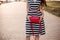 Woman holding pink handbag in hands after shopping.