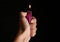 Woman holding pink lighter on black background, closeup