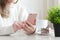 Woman holding a pink mobile phone in a cafe