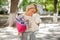 Woman holding a pretty composition of flowers and toy