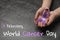 Woman holding purple awareness ribbon on background, closeup. World Cancer Day