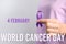 Woman holding purple ribbon against background, closeup. World Cancer Day