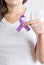 Woman holding a purple ribbon of the International Day for the Elimination of Violence Against Women