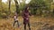 A woman is holding a rake. Cleaning of fallen yellow and orange foliage. Daughter helps mom