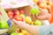 Woman holding red and green apples in the supermarket. Vegetables and fruits in the background. Shopping concept.