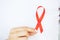 A woman holding a red ribbon emerges from a critical situation after overcoming AIDS