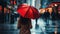 A Woman is holding a red umbrella and walking on a city street. Rainy weather.