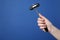 Woman holding reflex hammer on blue background, closeup with space for text. Nervous system diagnostic