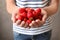 Woman holding ripe strawberries on grey background