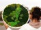 Woman holding a round panel of stabilized moss in her hands