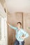 Woman Holding Scraping Tool In Unrenovated Room