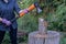 Woman, holding a sharp ax and chopping firewood.