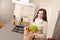 Woman holding shopping bag with grocery in kitchen