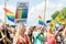 Woman holding a sign Proud parents of LGBT children in happy crowd waving rainbow flags during Stockholm Pride Parade