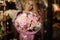 Woman holding a spring bouquet of tender rosy color roses in the wrapping paper