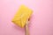 Woman holding stylish envelope bag on background, closeup