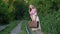 Woman holding suitcase and looking out on railway tracks