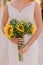 Woman holding sunflowers bouquet at sunset