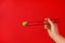 Woman holding swirl of wasabi paste with chopsticks on red background, closeup