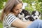 Woman holding three wonderful purebred husky puppies in her hands outdoors. A woman huging husky puppies