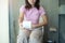 Woman holding toilet paper roll during sit on toilet bowl. diarrhea, constipated period, infection, abdominal, stomachache,