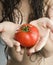 Woman holding tomatoes.