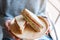 A woman holding two pieces of whole wheat sandwich