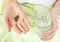 Woman holding two pills and a glass of water.