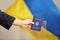 Woman holding Ukrainian internal passport against national flag at polling station,