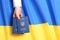 Woman holding Ukrainian travel passports over national flag, top view with space for text.