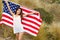 Woman holding USA flag outdoor.