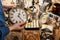 Woman holding vintage alarm clock near table with different stuff, closeup. Garage sale